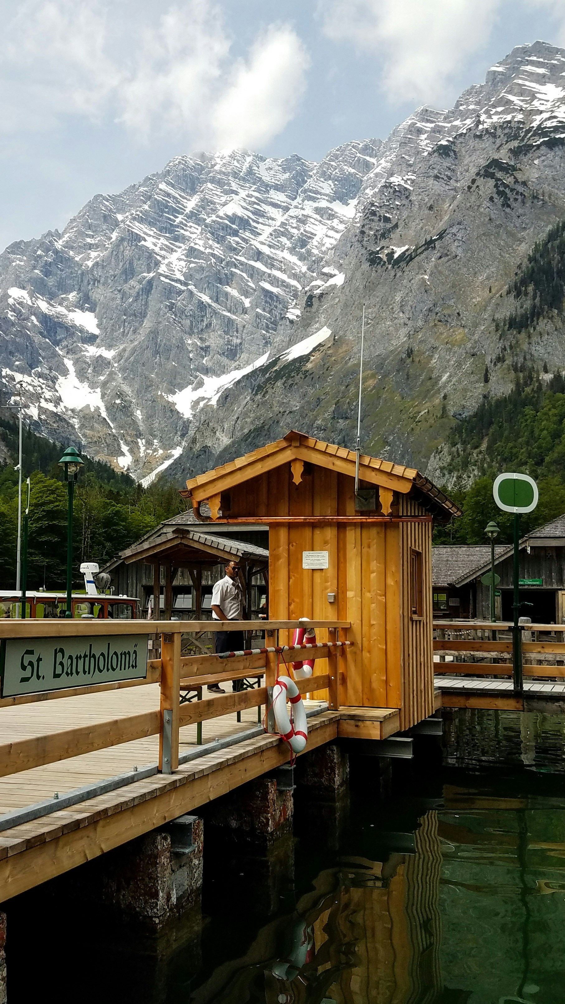 Braunes Holzhaus in der Nähe von grünen Bäumen und Bergen während des Tages