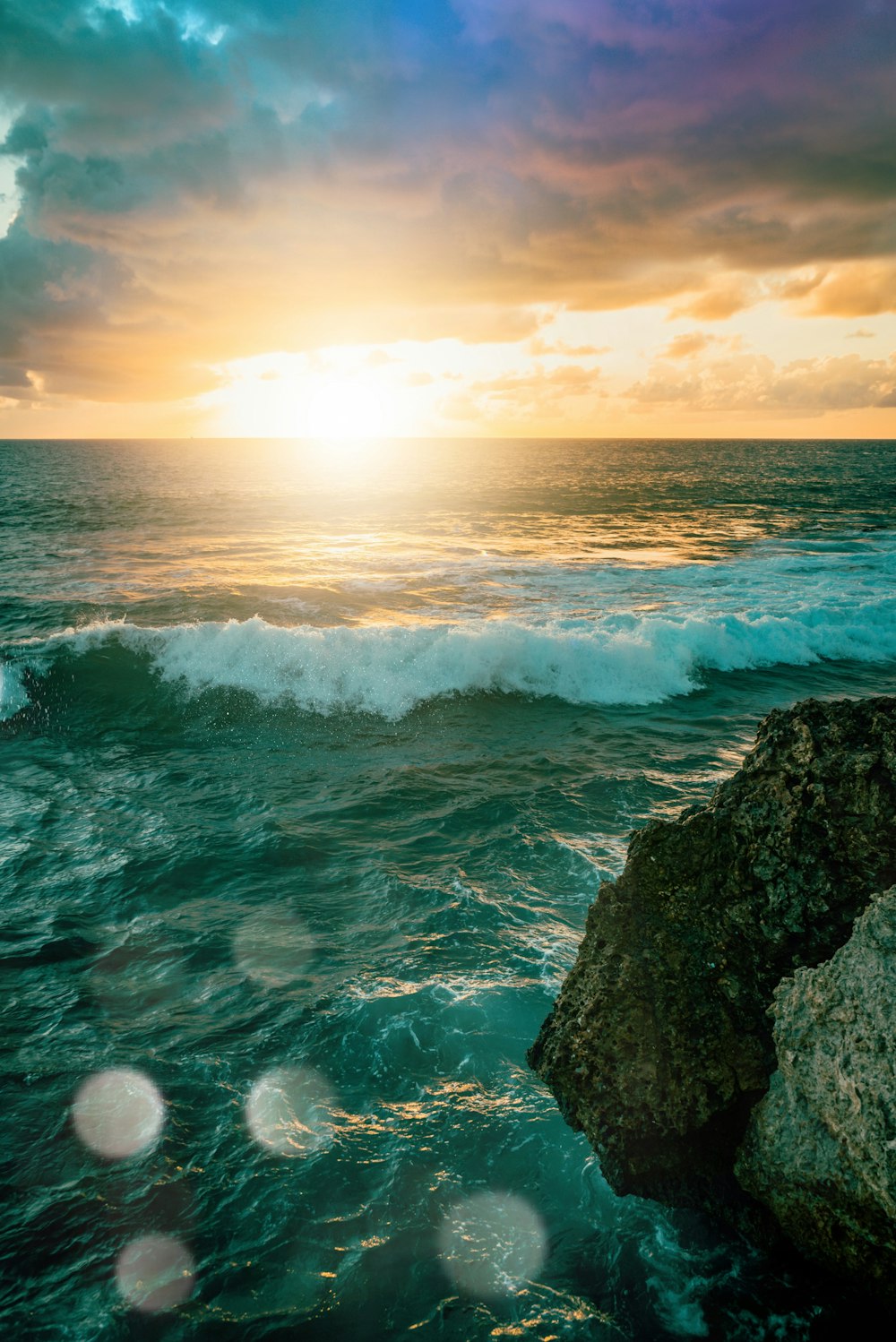 Meereswellen, die während des Sonnenuntergangs an Felsen brechen