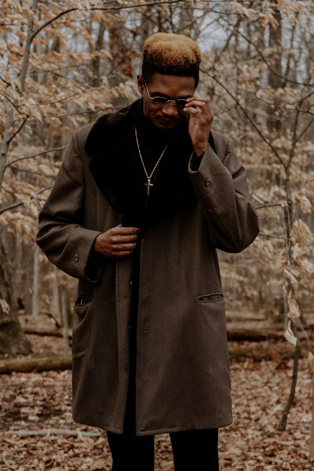 man in black coat holding black sunglasses