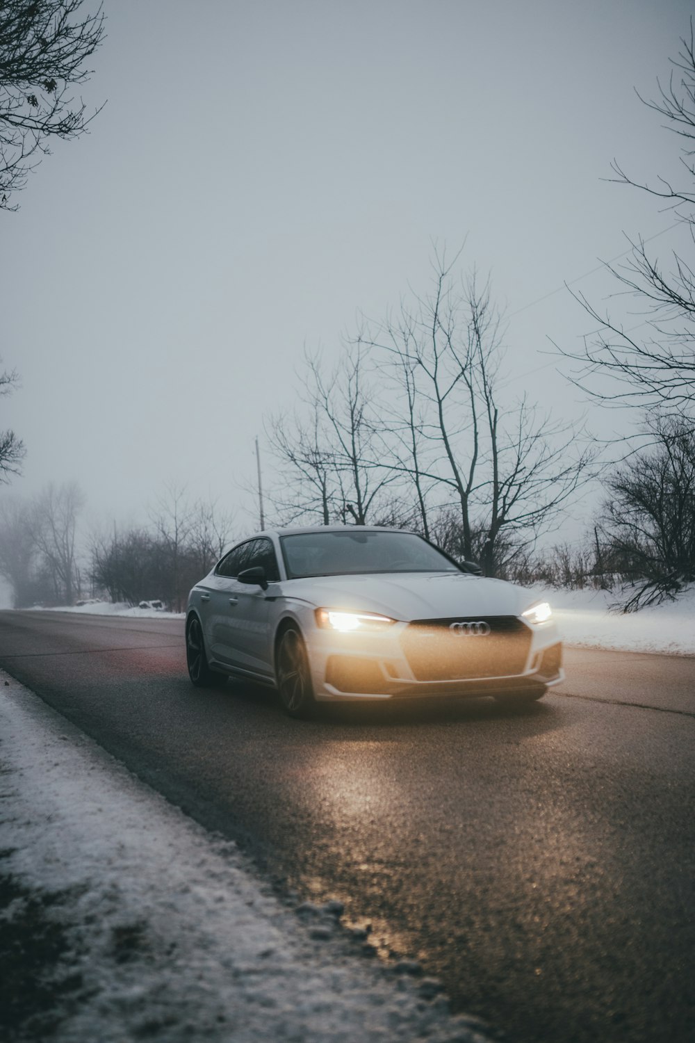 yellow car on road covered with snow