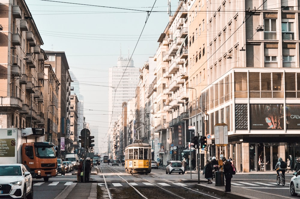 yellow tram on road near building during daytime