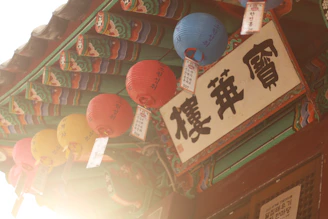 A warm, inviting photo of a cozy Korean street at dusk with soft lantern lights and traditional architecture.