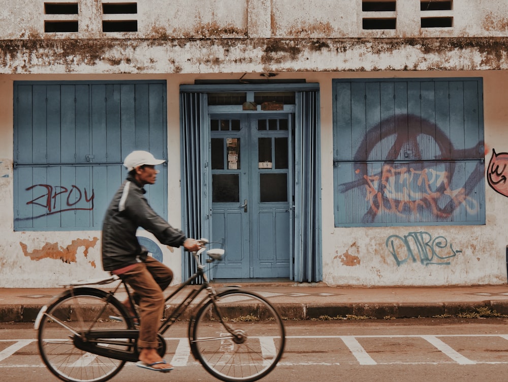 man in black jacket riding on bicycle during daytime