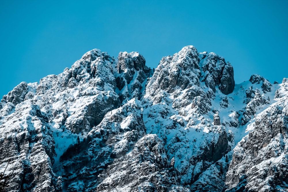 montanha coberta de neve sob o céu azul durante o dia