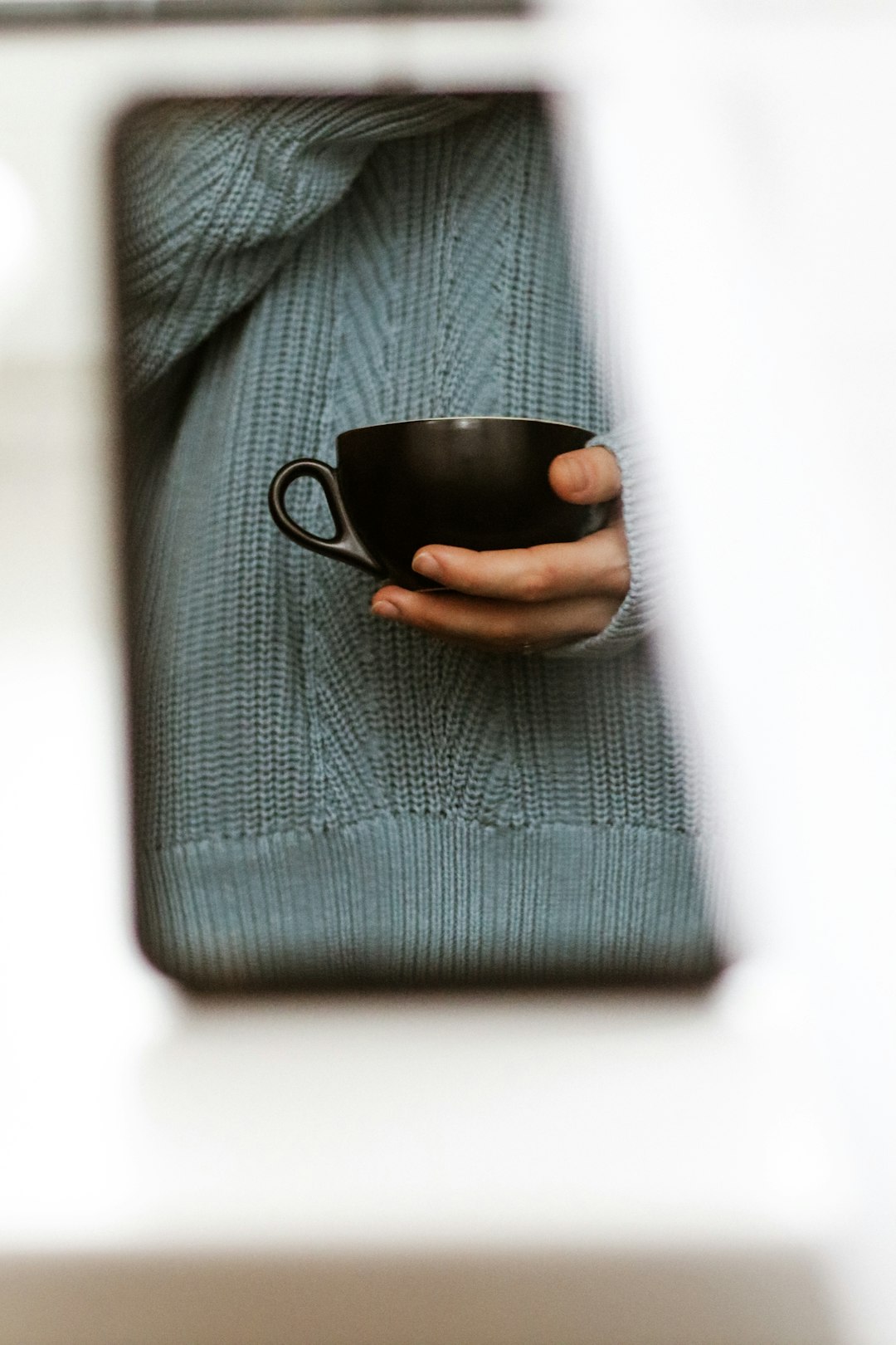 person holding black ceramic mug