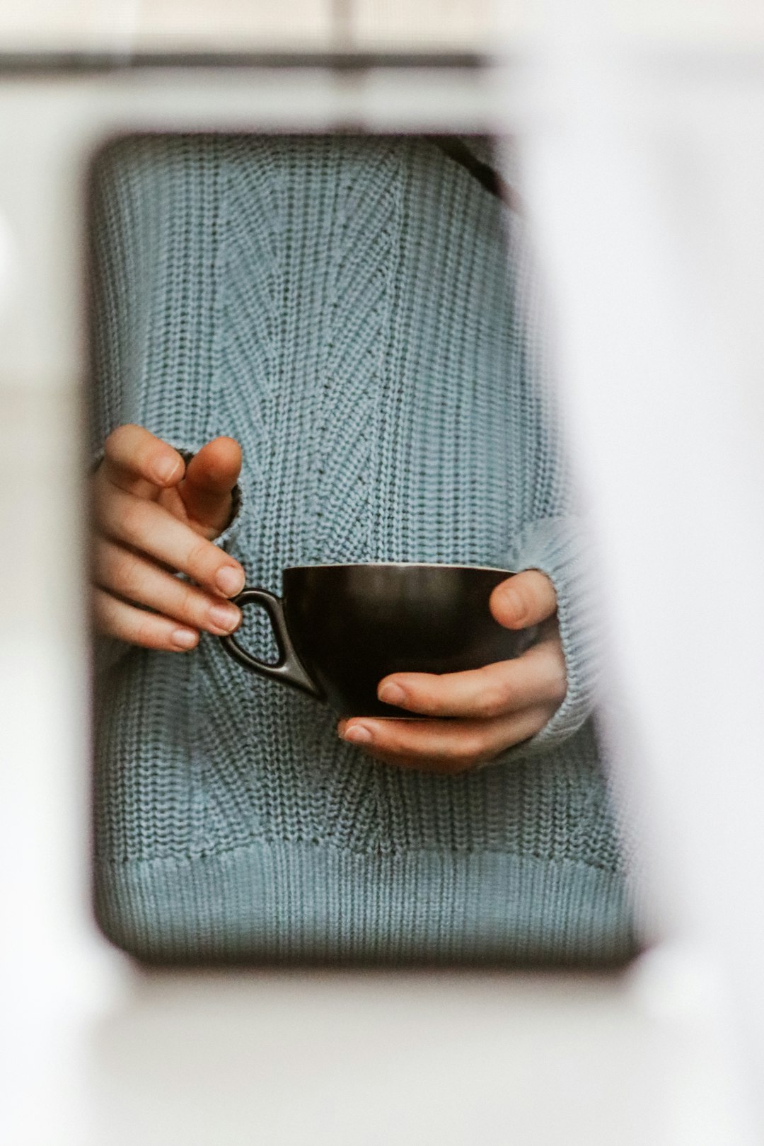 person holding black ceramic mug