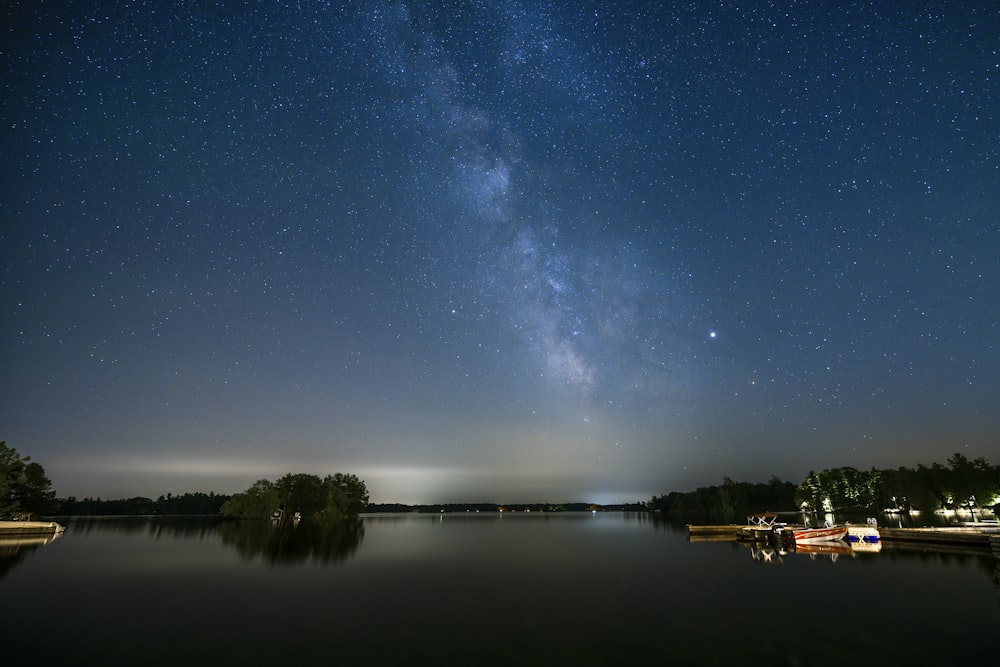 body of water near trees during night time