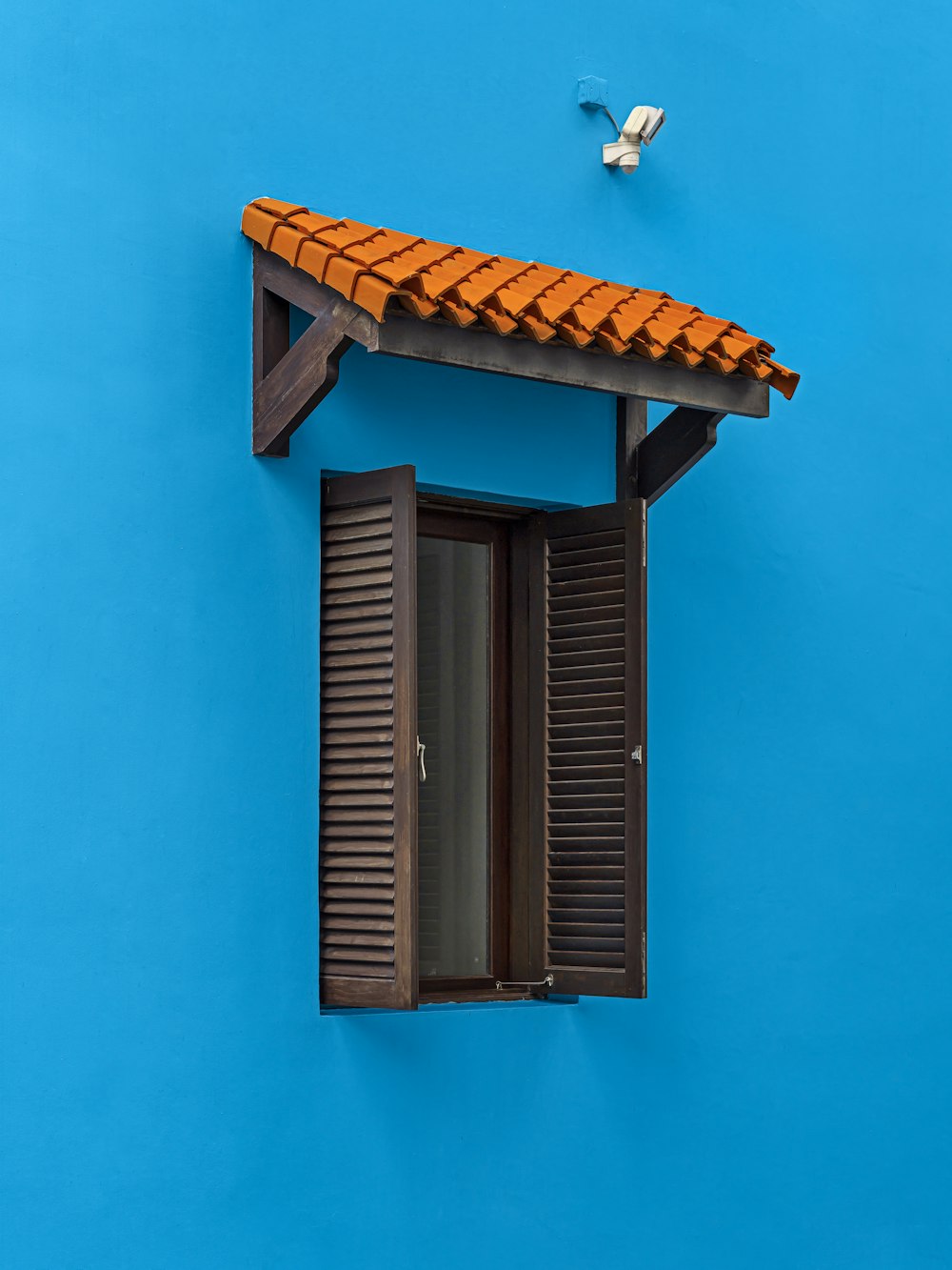 marco de ventana de madera marrón en pared azul