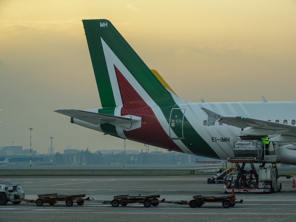 white and red passenger plane on airport during daytime