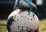 white and blue soccer ball on green grass field