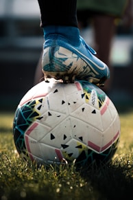 white and blue soccer ball on green grass field