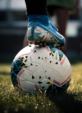 white and blue soccer ball on green grass field