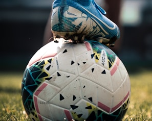 white and blue soccer ball on green grass field