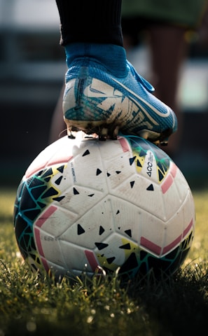 white and blue soccer ball on green grass field