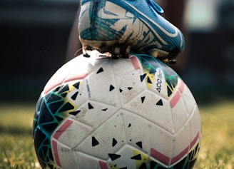 white and blue soccer ball on green grass field