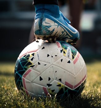 white and blue soccer ball on green grass field