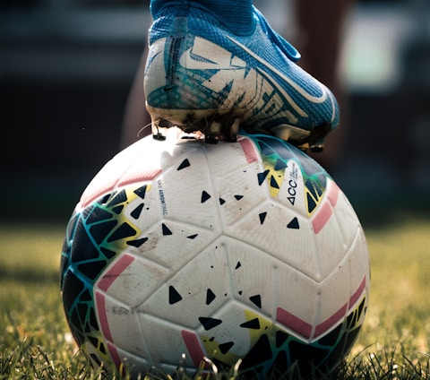 white and blue soccer ball on green grass field