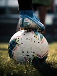 white and blue soccer ball on green grass field
