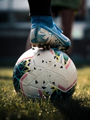 white and blue soccer ball on green grass field