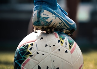 white and blue soccer ball on green grass field