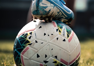 white and blue soccer ball on green grass field