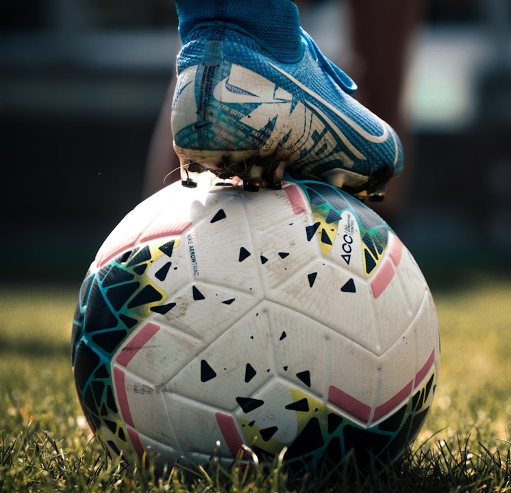 white and blue soccer ball on green grass field