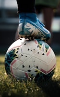 white and blue soccer ball on green grass field