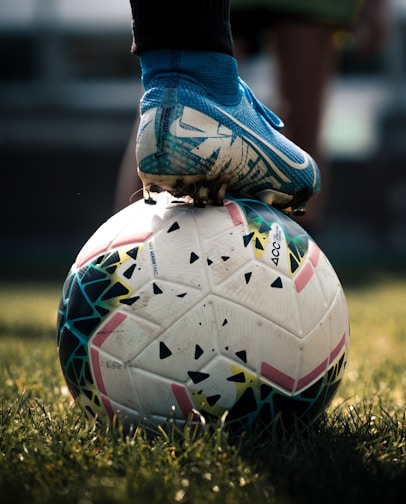 white and blue soccer ball on green grass field