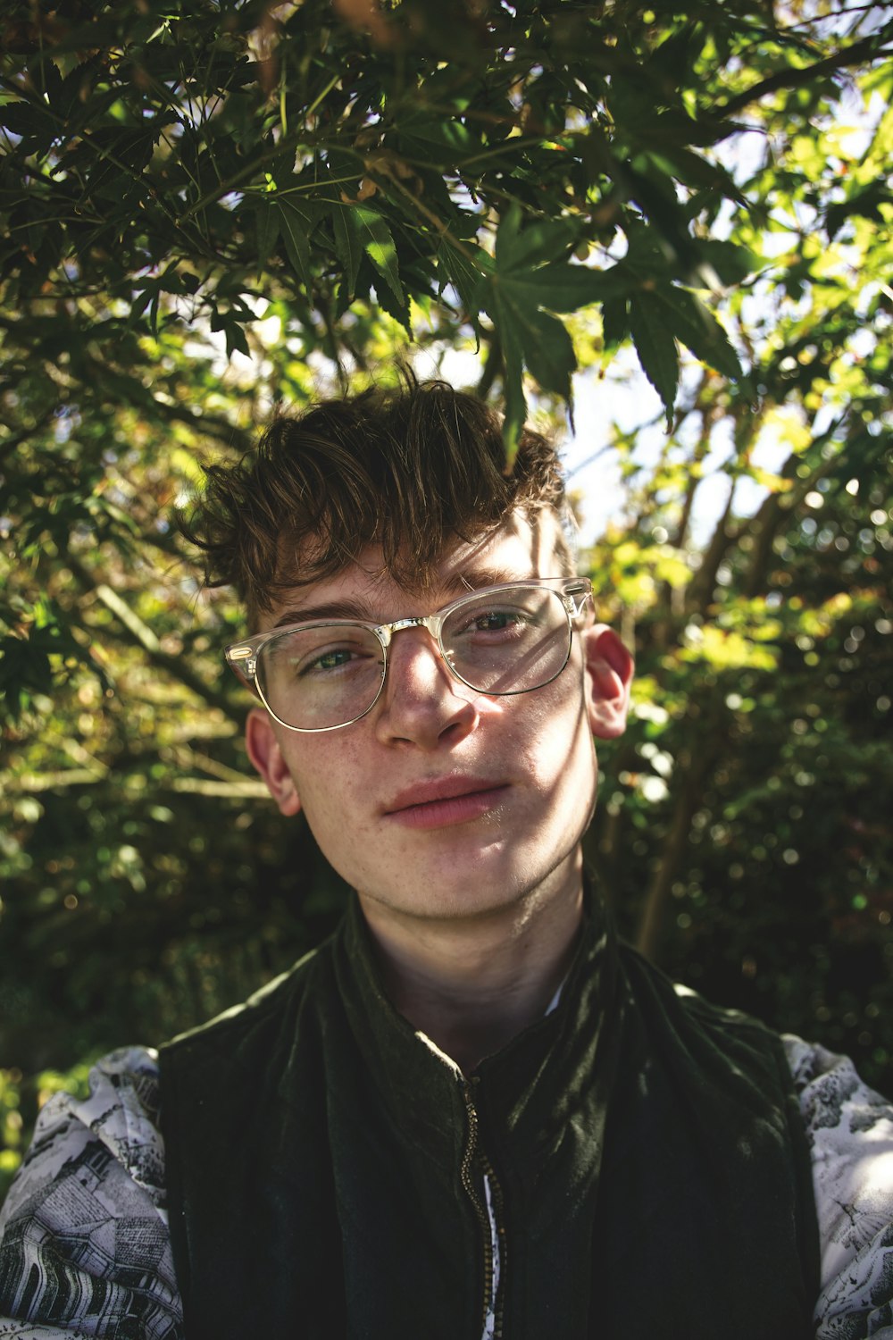 man in black and white floral shirt wearing eyeglasses