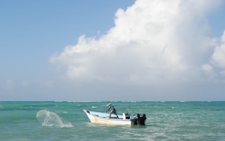 Fisherman casting a trolling line from a traditional Sri Lankan boat against a turquoise ocean backdrop.