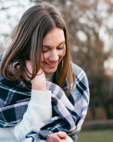 A peaceful moment after treatment with a client smiling softly, wrapped in a cozy blanket.