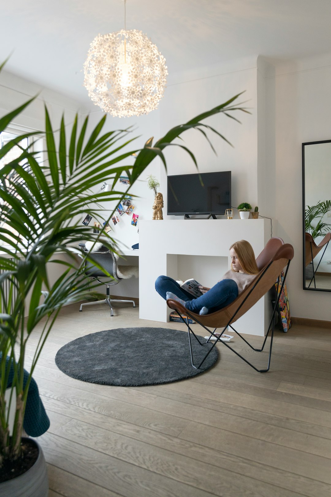 woman in blue denim jeans lying on brown and black padded chair