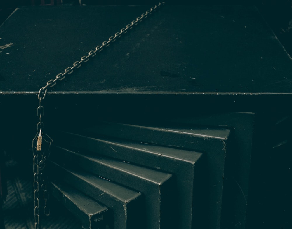 silver chain on black wooden stairs