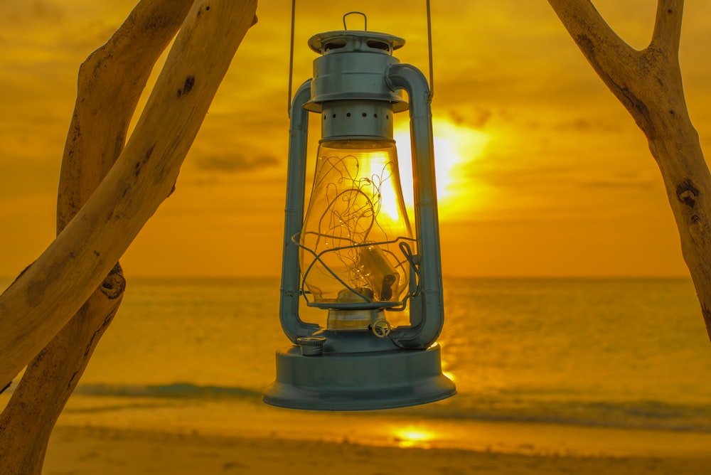 black lantern lamp on brown wooden post during sunset