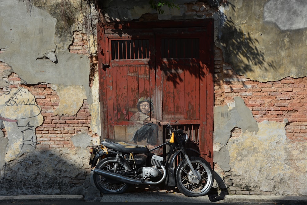 black motorcycle parked beside brown wooden door