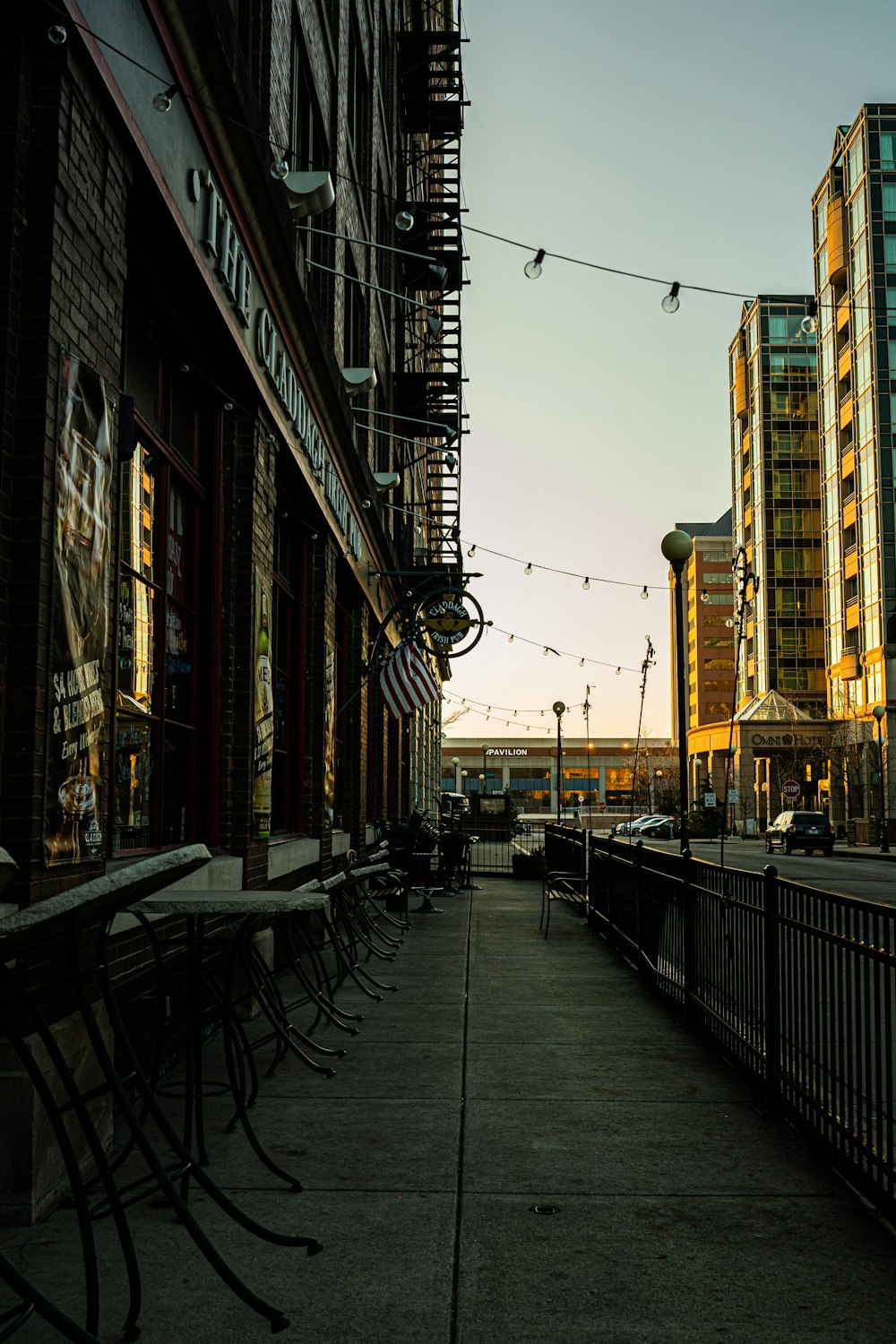 black metal chairs and tables on sidewalk during daytime