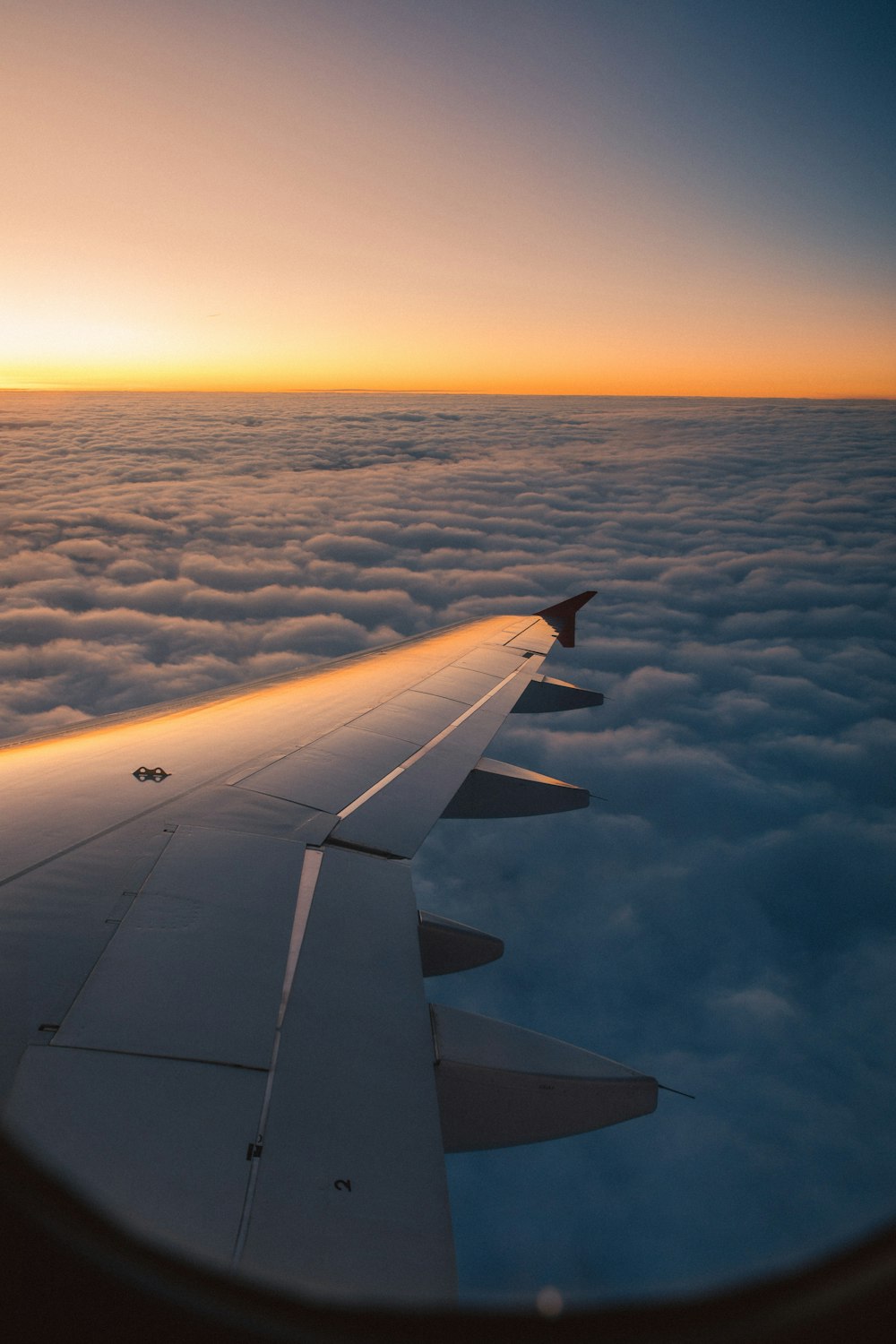 white and gray airplane wing over blue sea during daytime