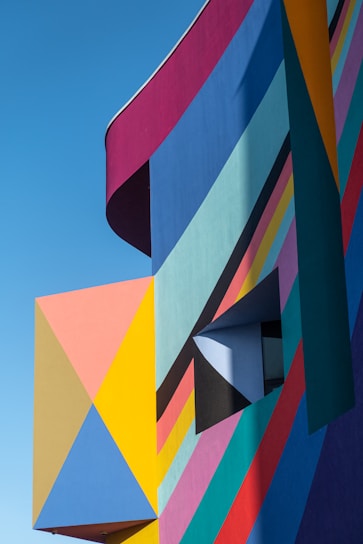 Colorful educational center with blue, red, and yellow triangles inspired by Rarámuri patterns.