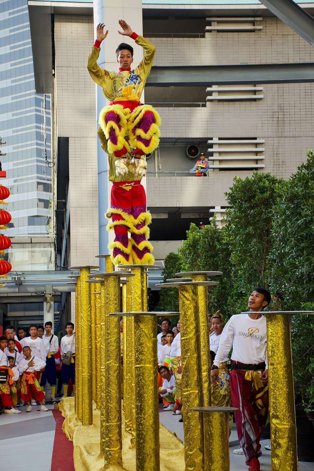 man in white crew neck t-shirt standing near yellow and red dragon statue during daytime