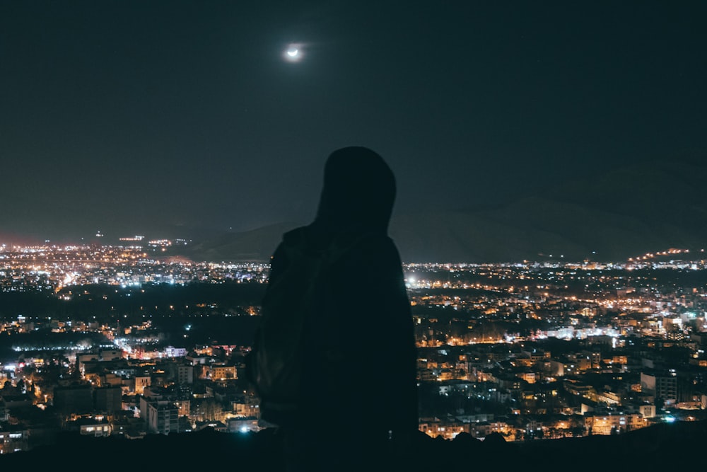 Silhouette einer Person, die nachts auf dem Dach des Gebäudes steht