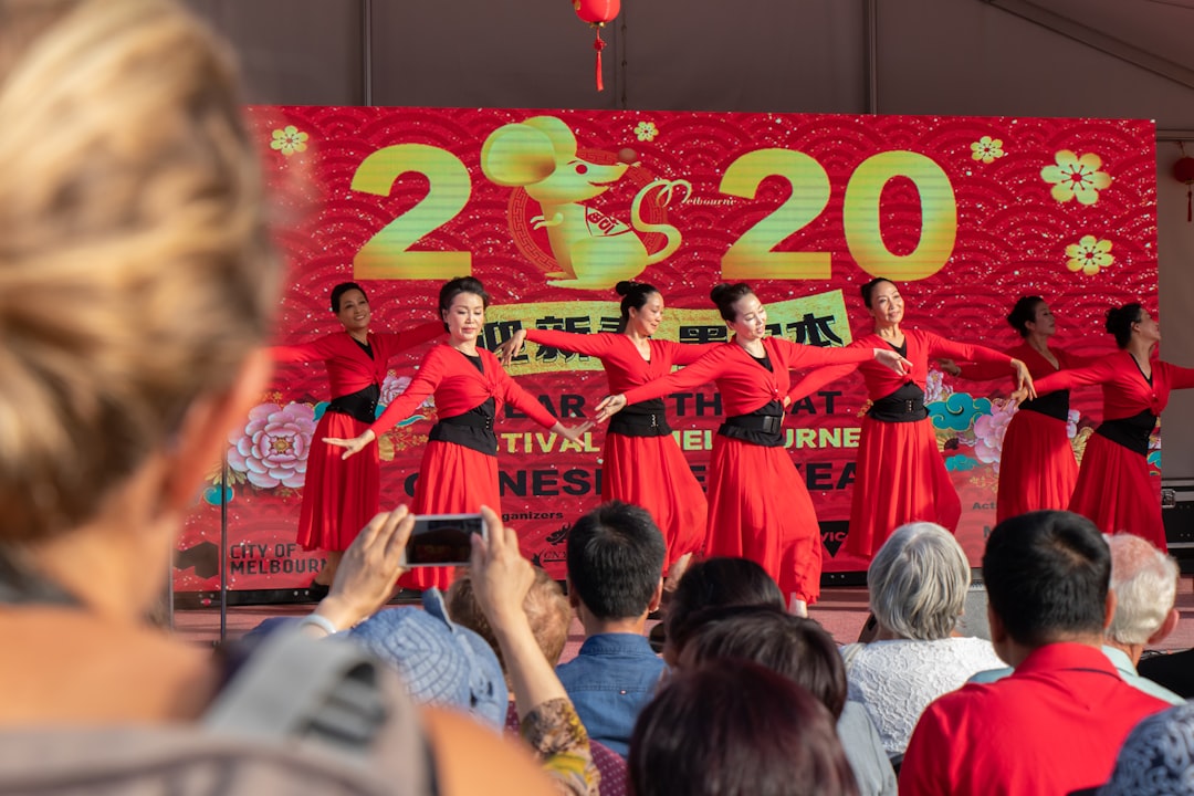 people in red shirts standing near red and white kanji text wall