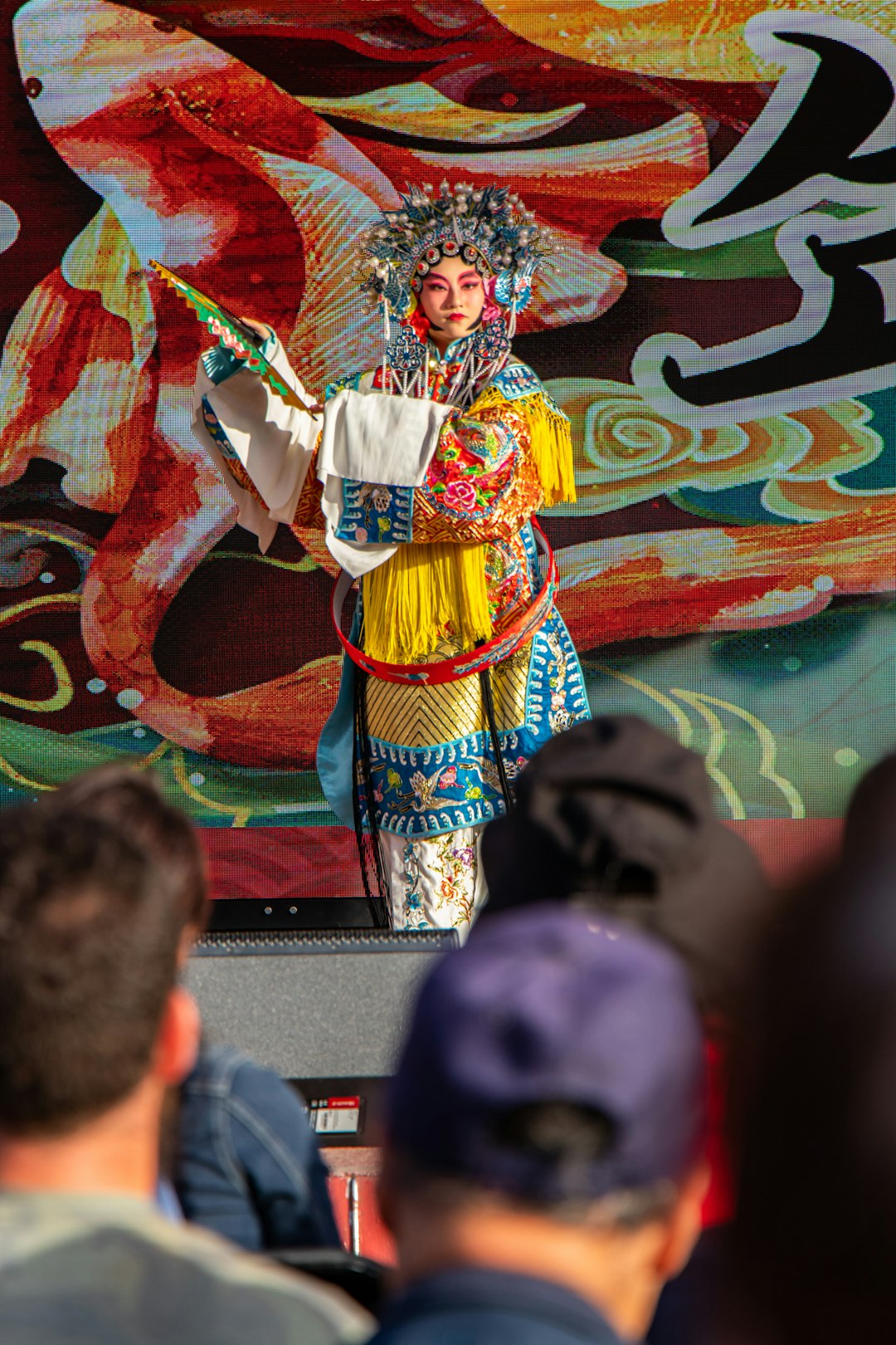 man in yellow and red traditional dress dancing on stage