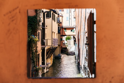 brown concrete building beside river during daytime