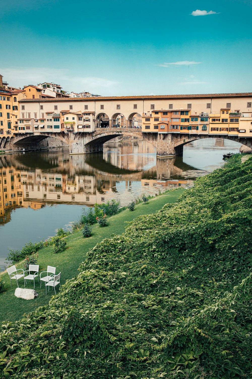 Bâtiment en béton brun près de l’herbe verte et du plan d’eau pendant la journée