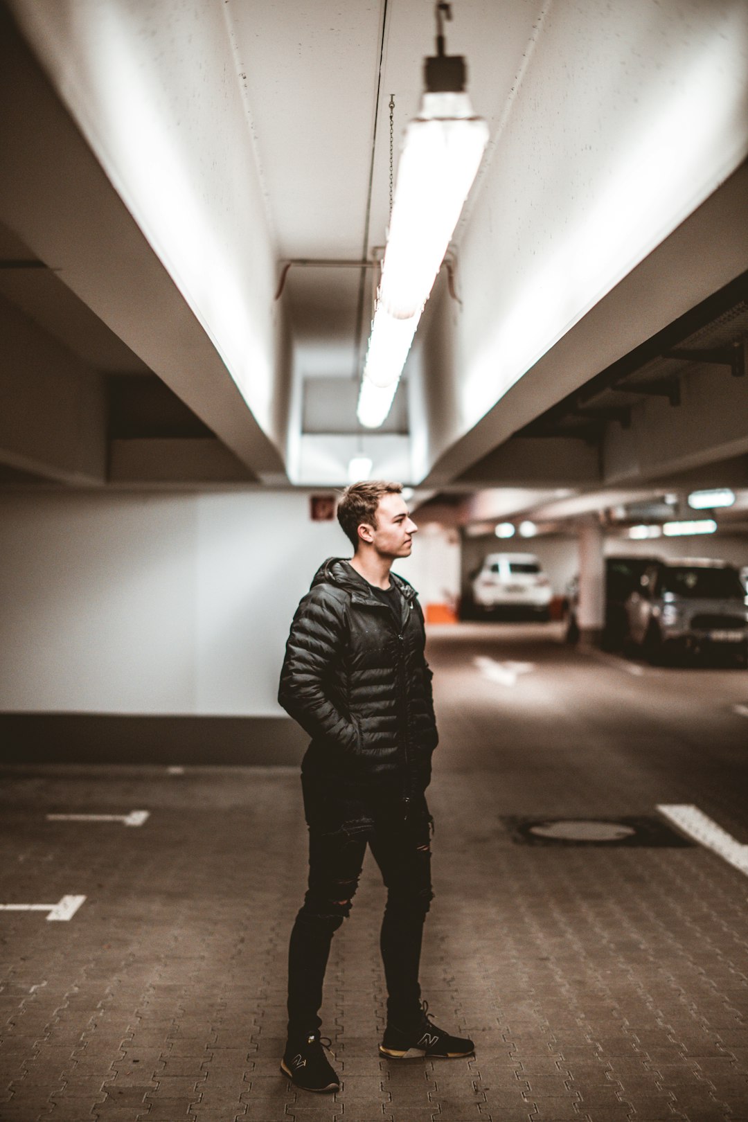 man in black leather jacket standing on hallway