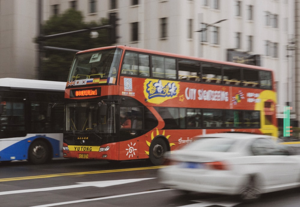 red and yellow double decker bus on road during daytime