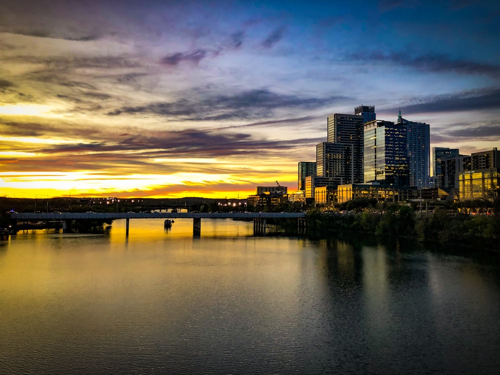 city skyline across body of water during sunset