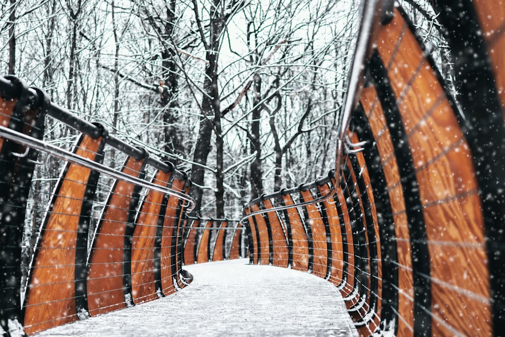 brown wooden bench covered with snow