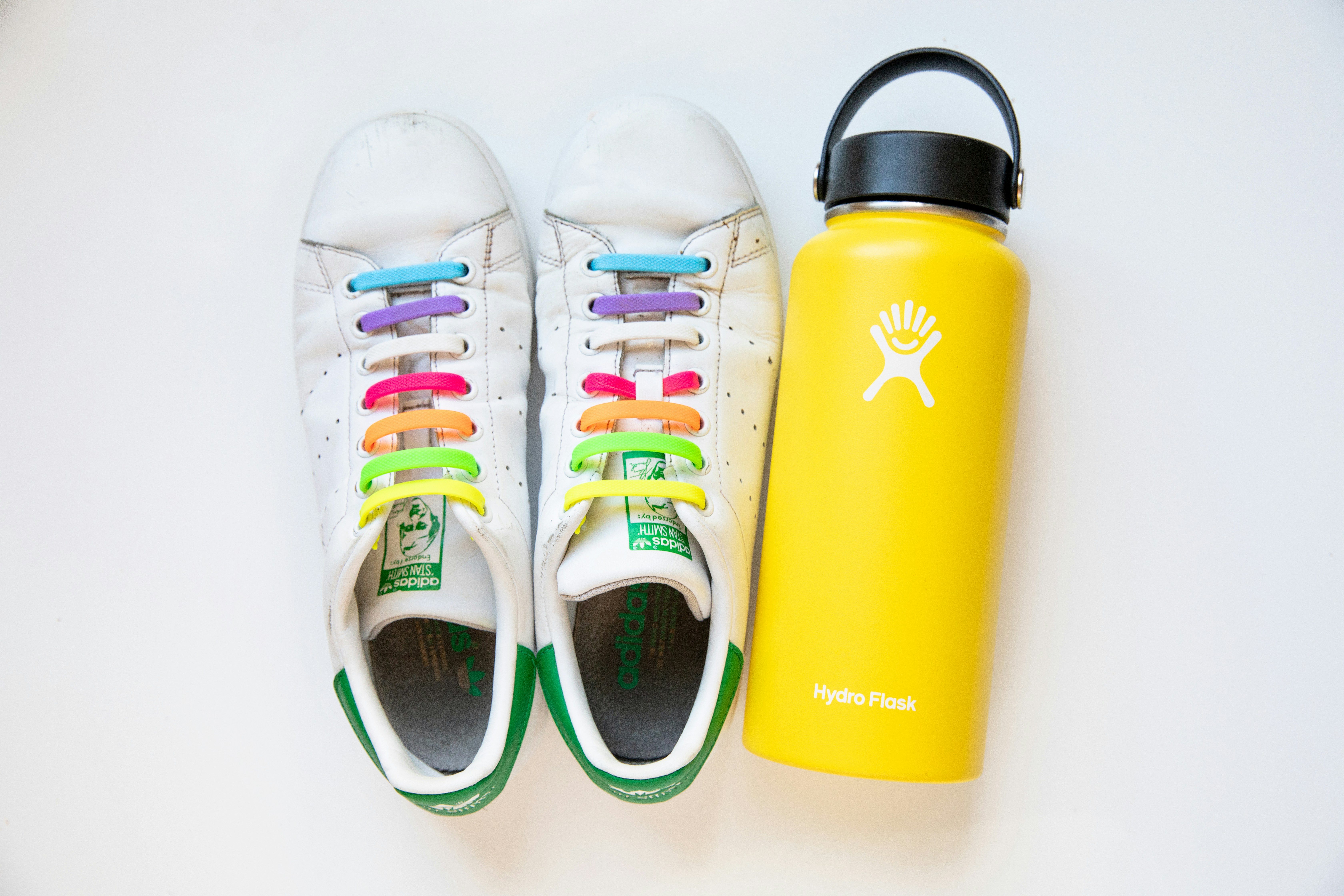 a pair of tennis shoes next to a water bottle