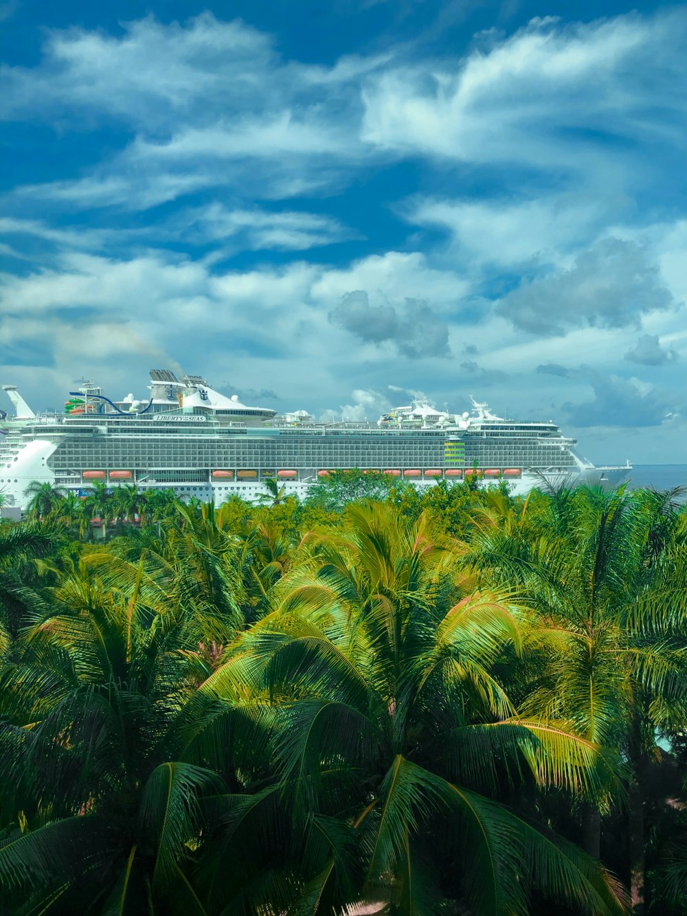 white cruise ship on sea under blue sky and white clouds during daytime